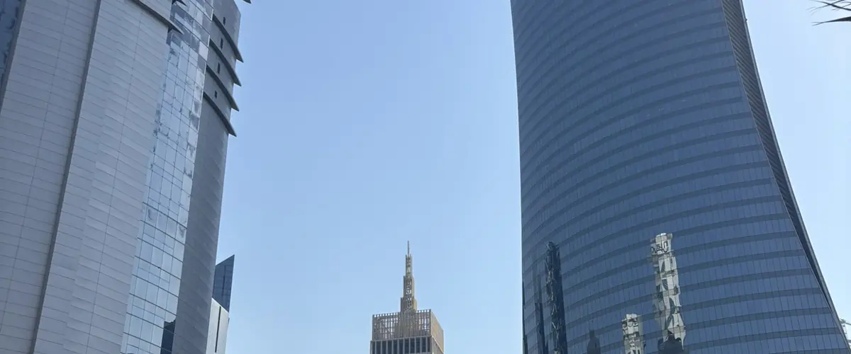 Two office towers framing a distant tower in the Doha business district